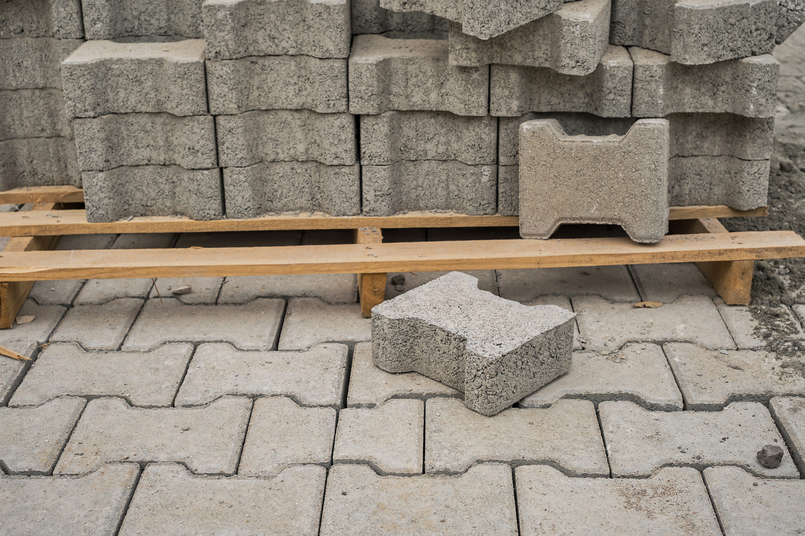 paving slabs stacked on a pallet, road repair process, close up, selective focus on tiles, seasonal reconstruction of pavement in walking paths in parks